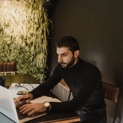 A Man Typing on a Laptop
