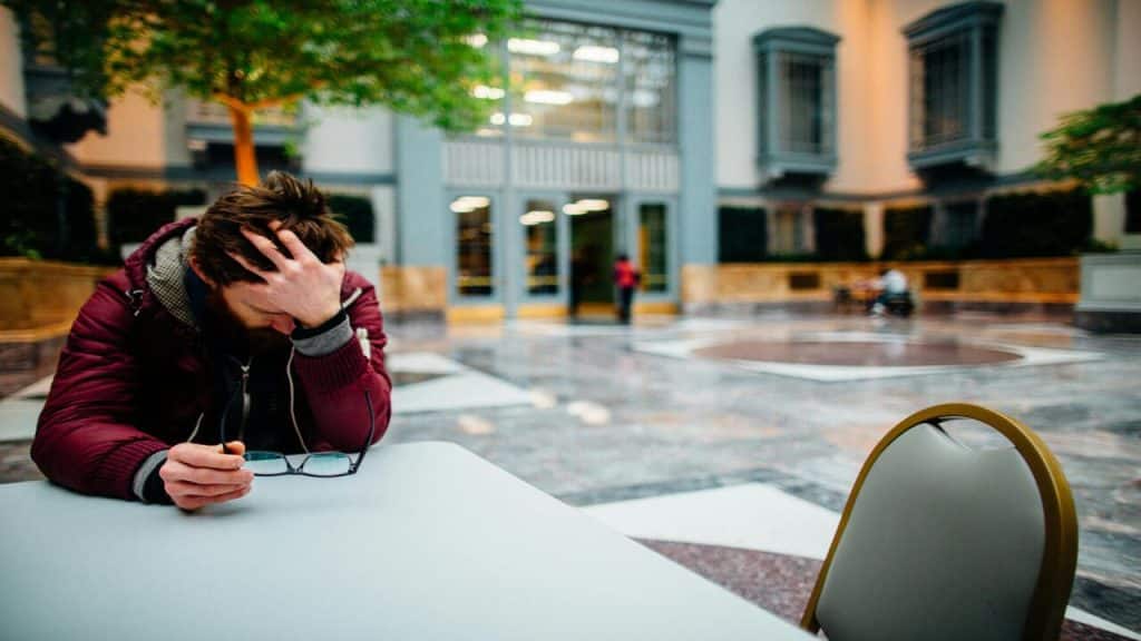 A man looking stressed outdoors