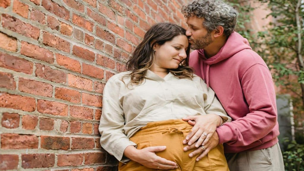 A man giving his wife a forehead kiss