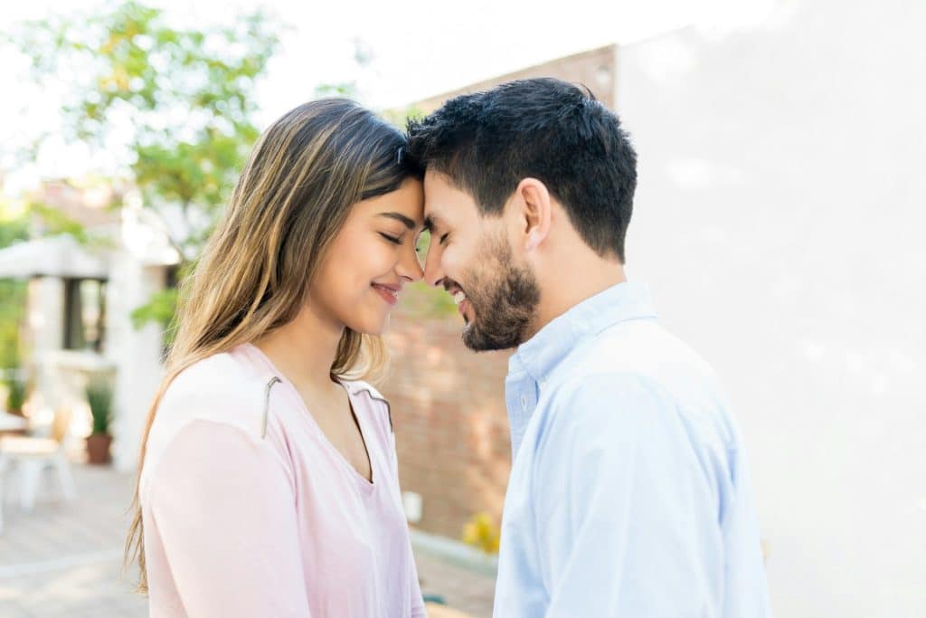 The woman’s and man’s foreheads are touching.