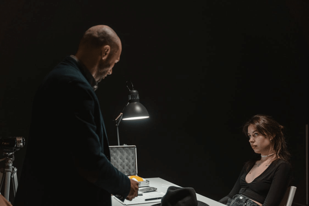 Man in Black Suit Standing In Front of Woman Sitting