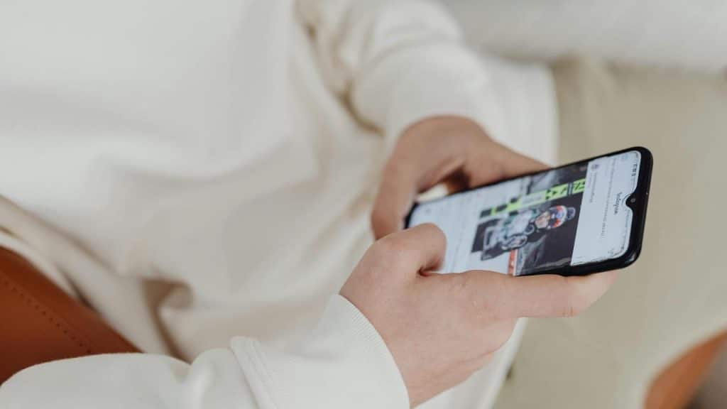 A person holding a smartphone and browsing photos.