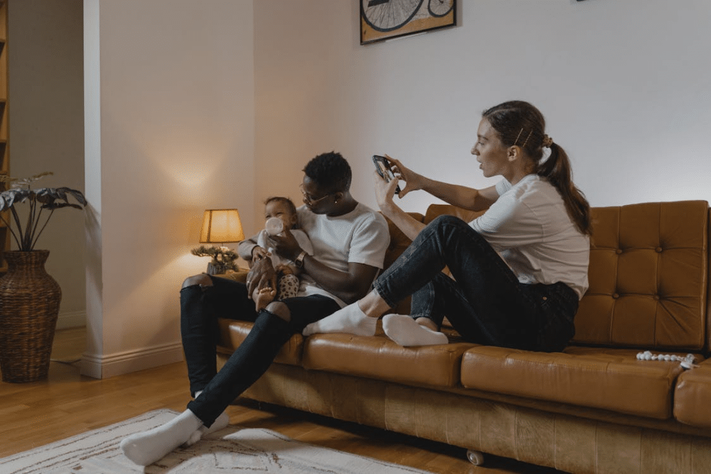 A Woman Taking Photo of a Man Feeding a Toddler