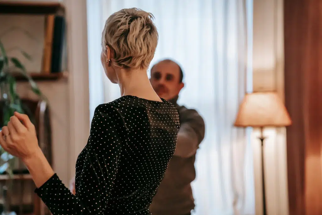 Couple dancing in light room near curtains