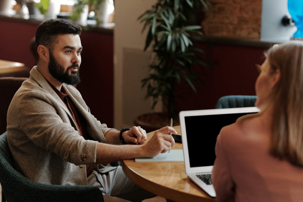 Man and a Woman Sitting on Table with Laptop