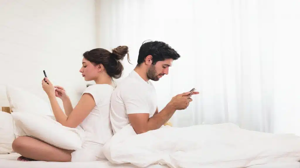 A couple ignoring each other in bed