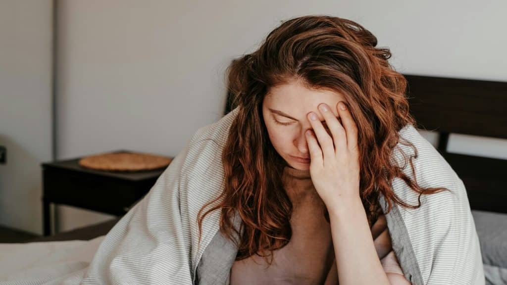 A woman looking sick at home