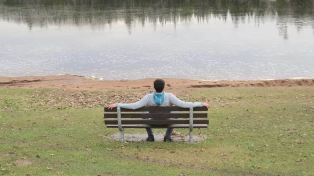 A man sitting quietly on a park bench, reflecting deeply.
