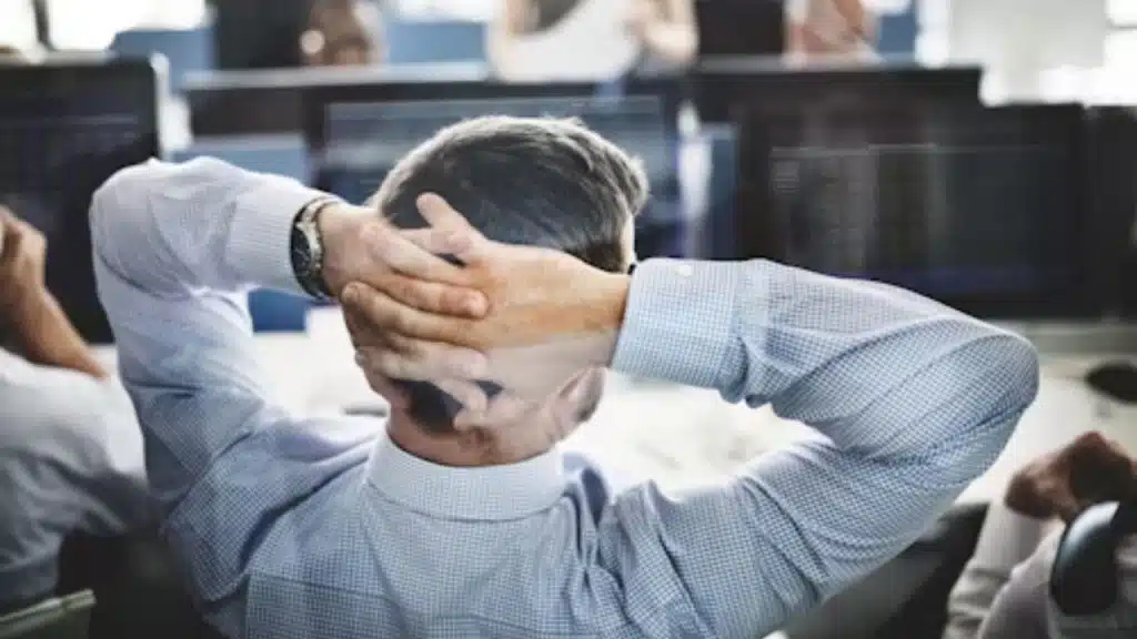 Man looking tired at work, resting his head on his hands