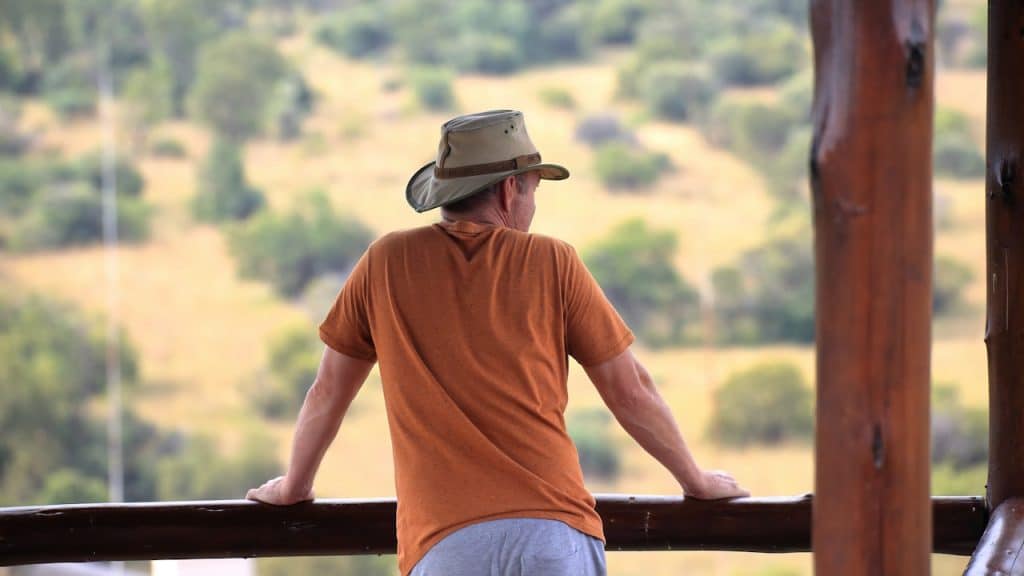 A man wearing a cowboy hat gazing at a picturesque view.