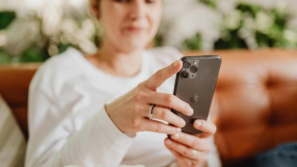 A person sitting on a couch using a smartphone.