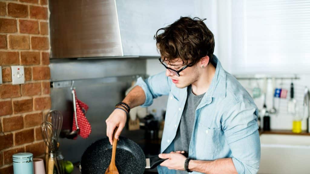 A Caucasian man cooking in the kitchen.