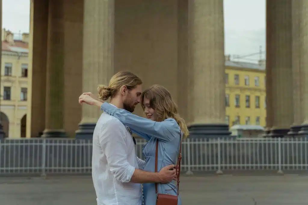 The couple is hugging each other on the street.