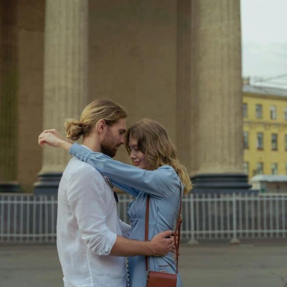 The couple is hugging each other on the street.
