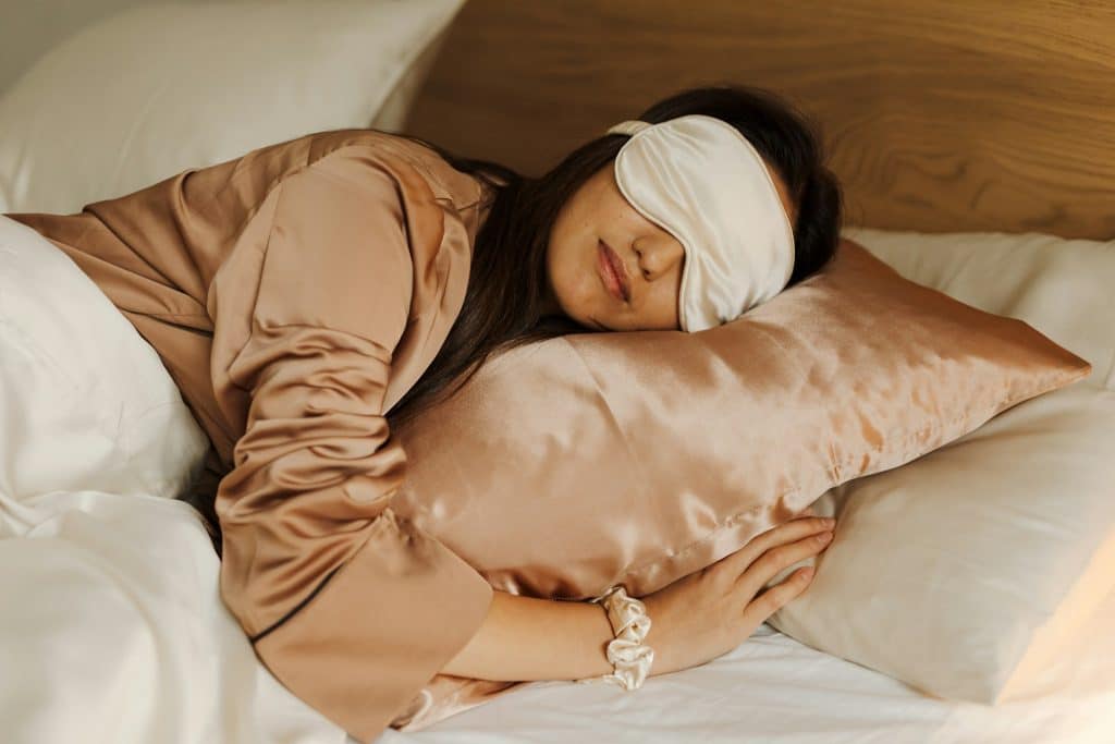 The woman is sleeping with a sleeping mask on her eyes.