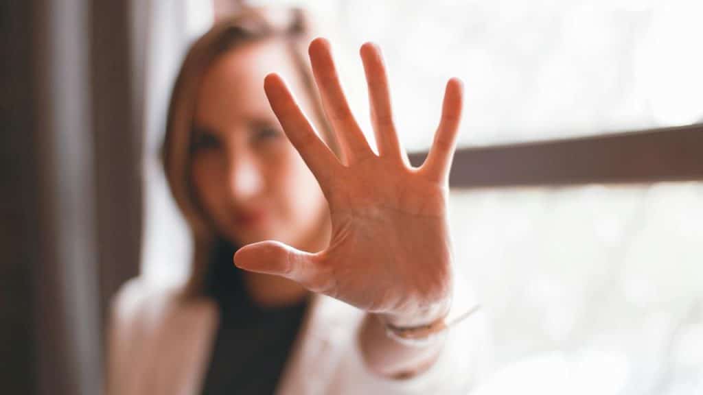 A person holding a hand up toward the camera.