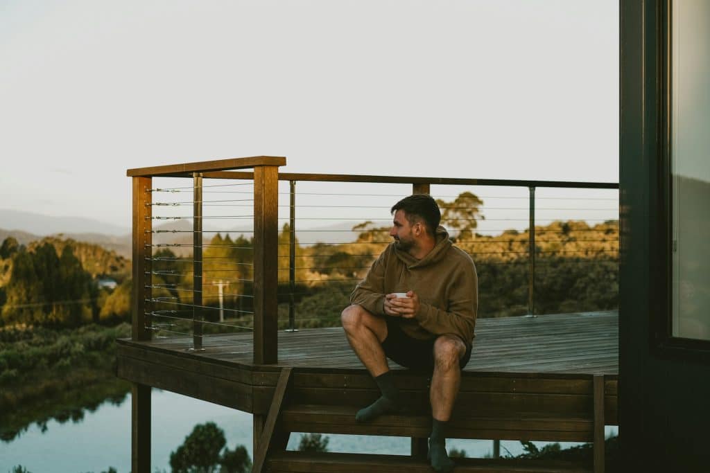 The man is enjoying the view while holding a cup of coffee.
