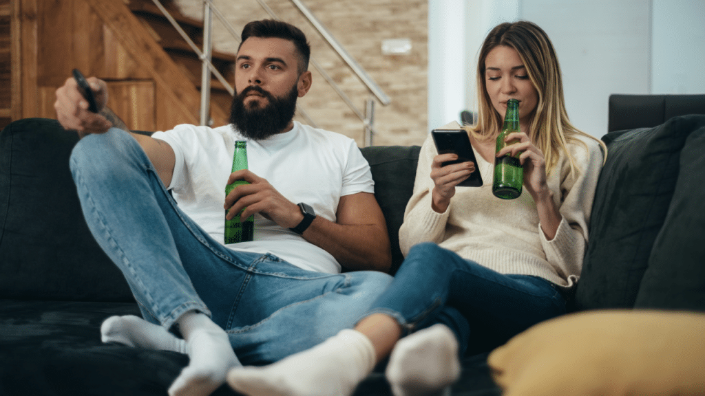 A couple having beer and watching TV