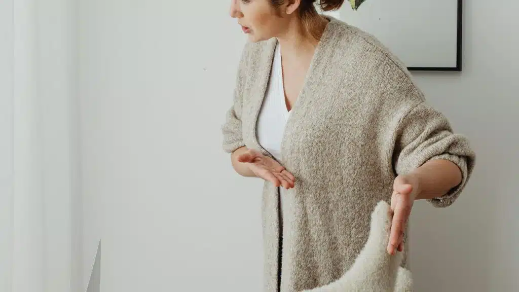 A woman standing and gesturing with her hands as if arguing or explaining.