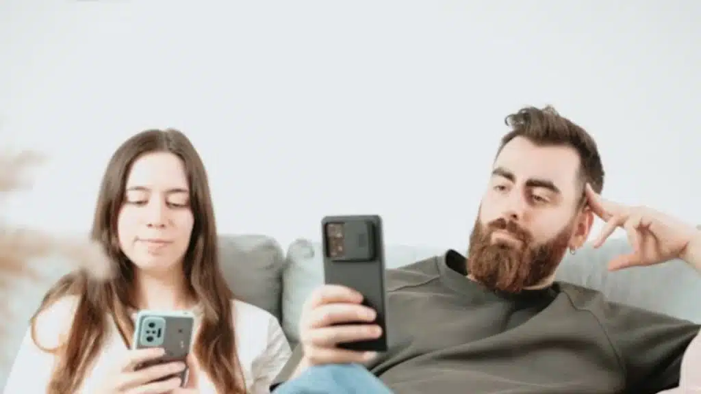 Couple sitting apart watching TV without interaction