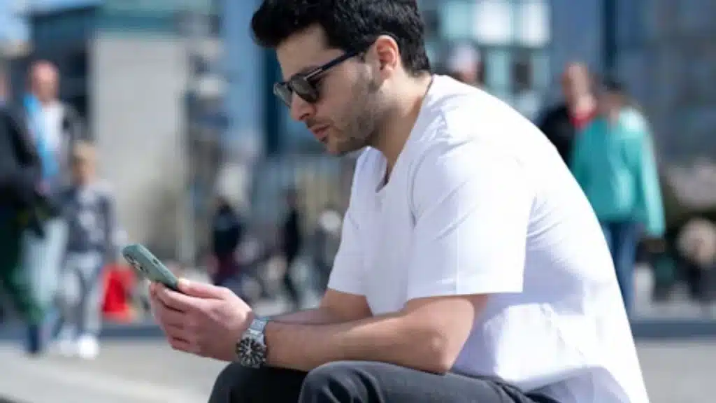 Man reading his phone calmly after a dating setback