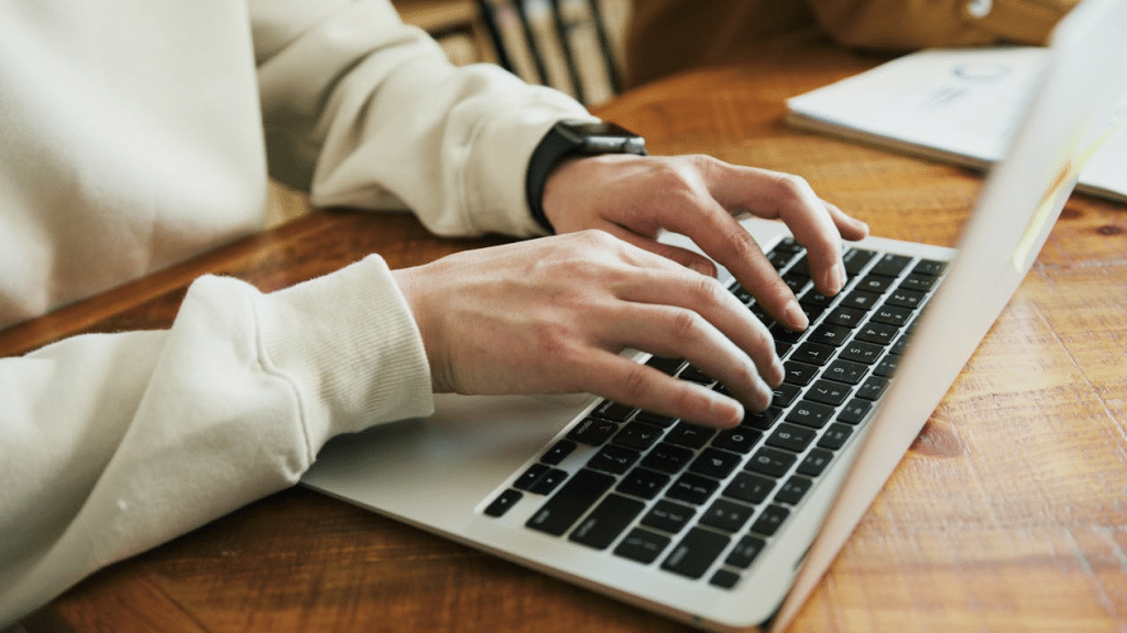Close Up Photo of a Person Typing on a Laptop