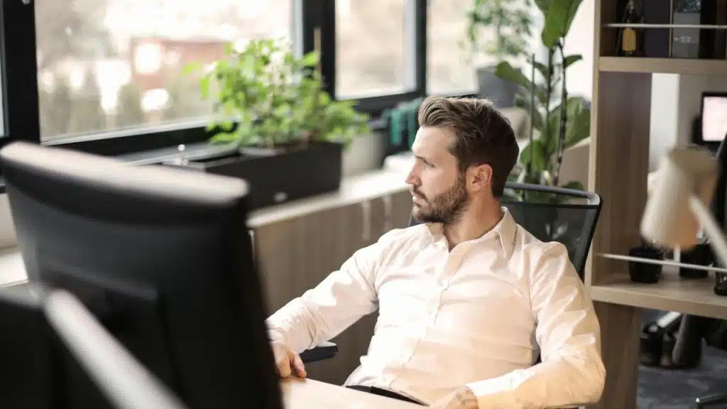 A man sitting at a desk looking out the window.