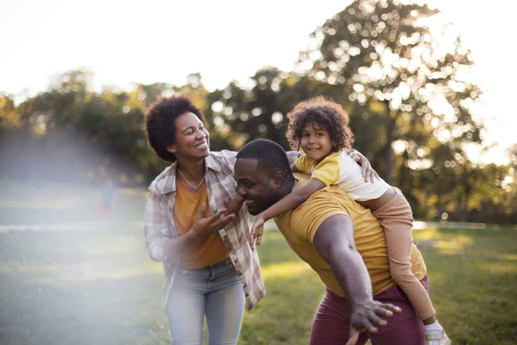 The young family is playing in the park.
