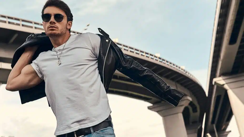 A handsome man standing under a ring road.