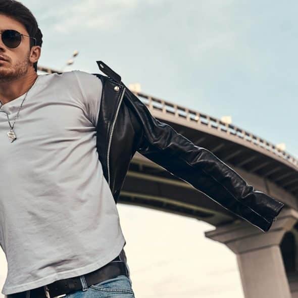 A handsome man standing under a ring road.