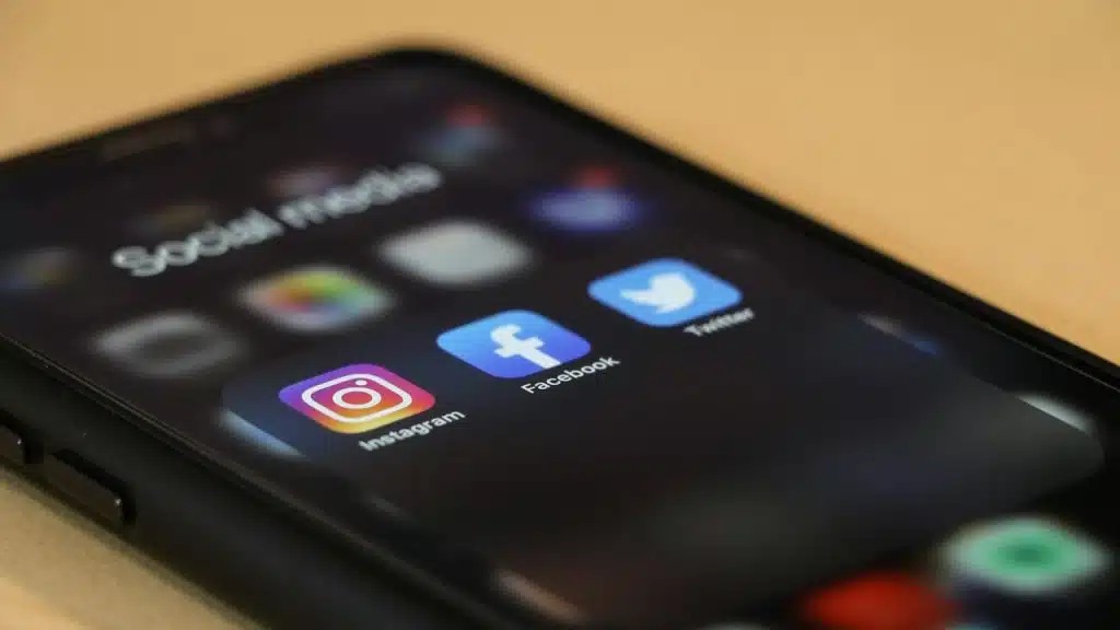 The screen of a mobile phone displaying a folder containing social networking app icons.