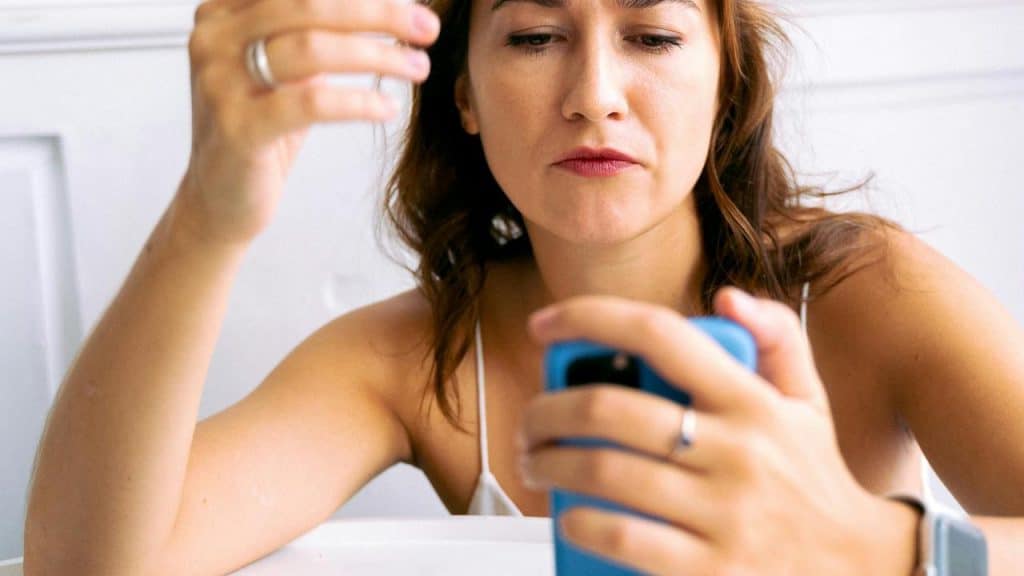 A person looking at their phone with a focused expression.
