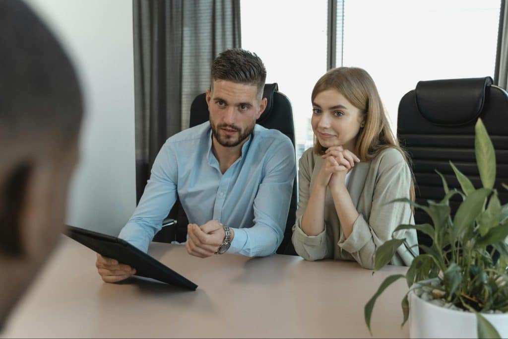 A man and woman listening to another man