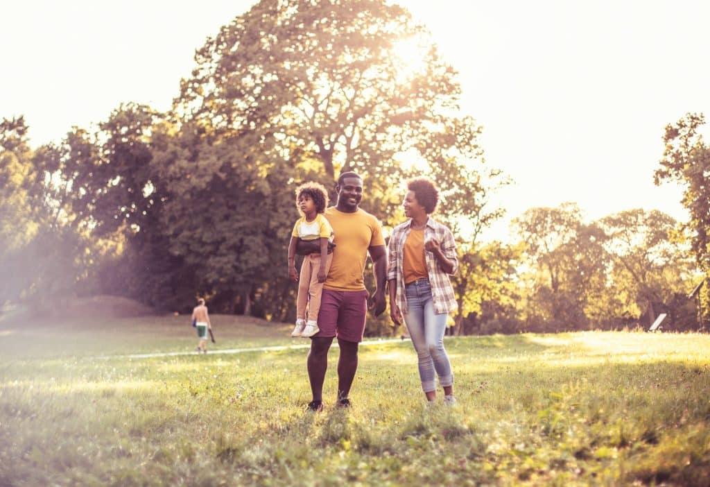 The young family is walking in the park.