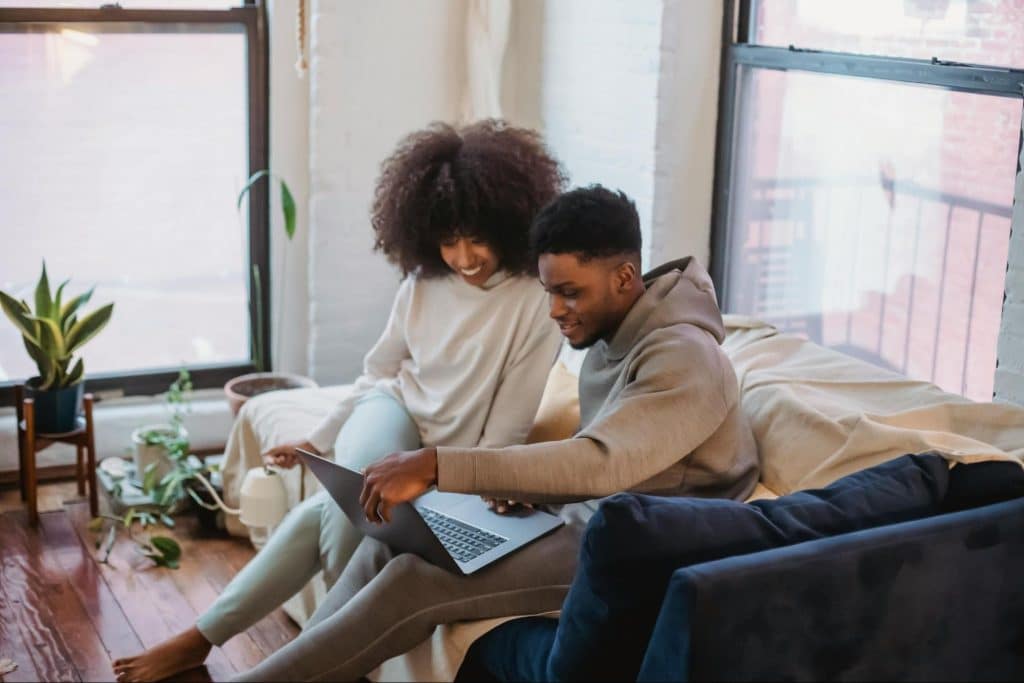 A man and woman looking at the laptop