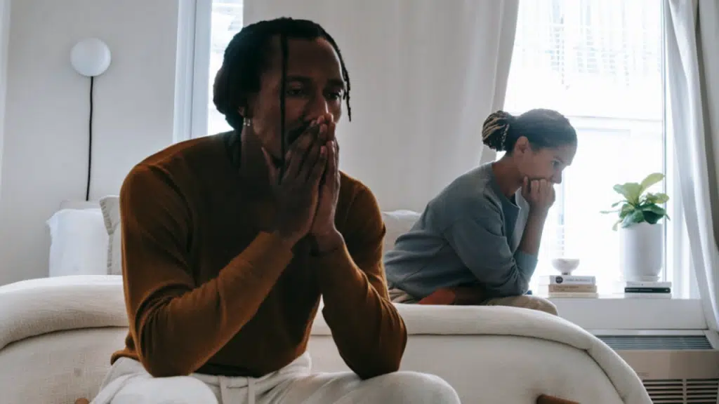 A couple looking sad in the bedroom