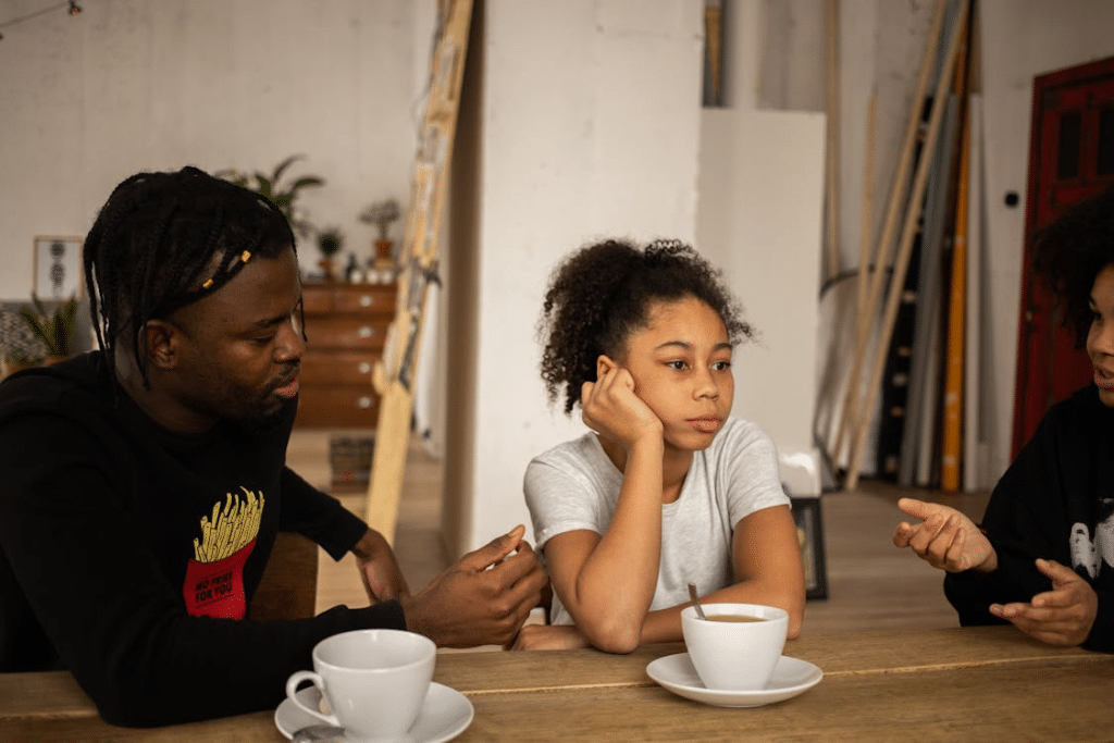 Frustrated girl between arguing parents at table