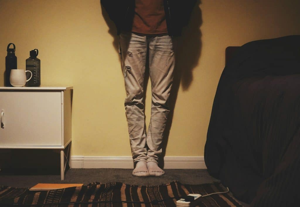 The person is standing in front of a yellow wall.
