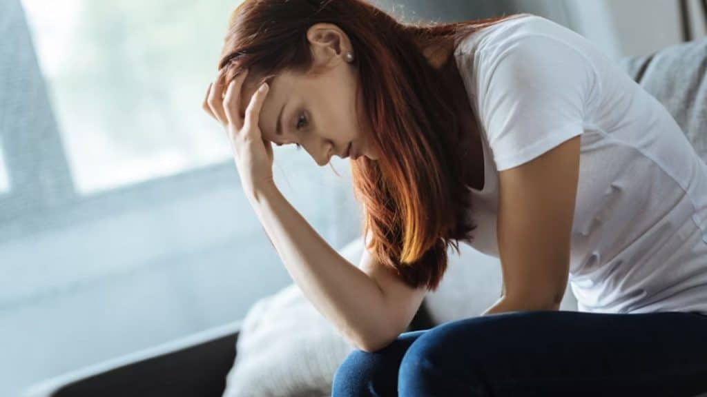 Woman resting her head on her hand, looking distant