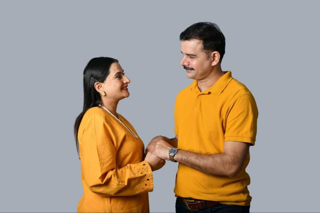A man and a woman holding their hands.