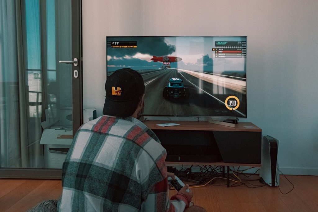 The man is playing video games at home.