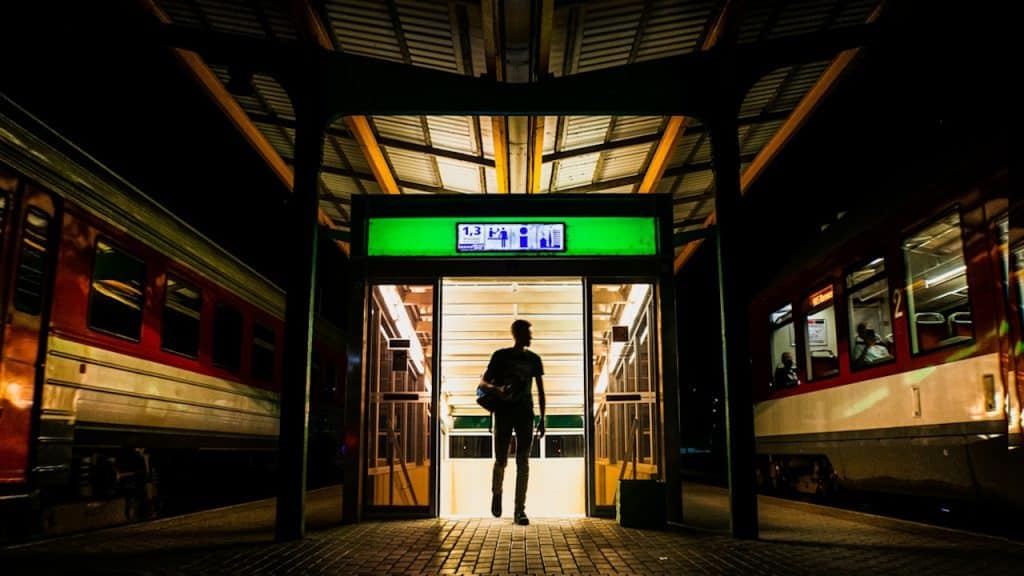 A man with a backpack entering a railway station.