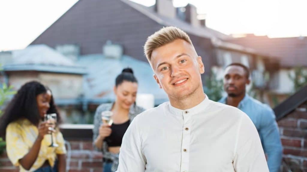 A man at a party standing apart from others