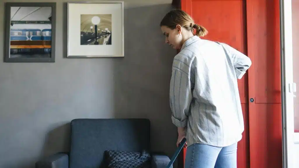 A woman vacuuming the floor in a living room.
