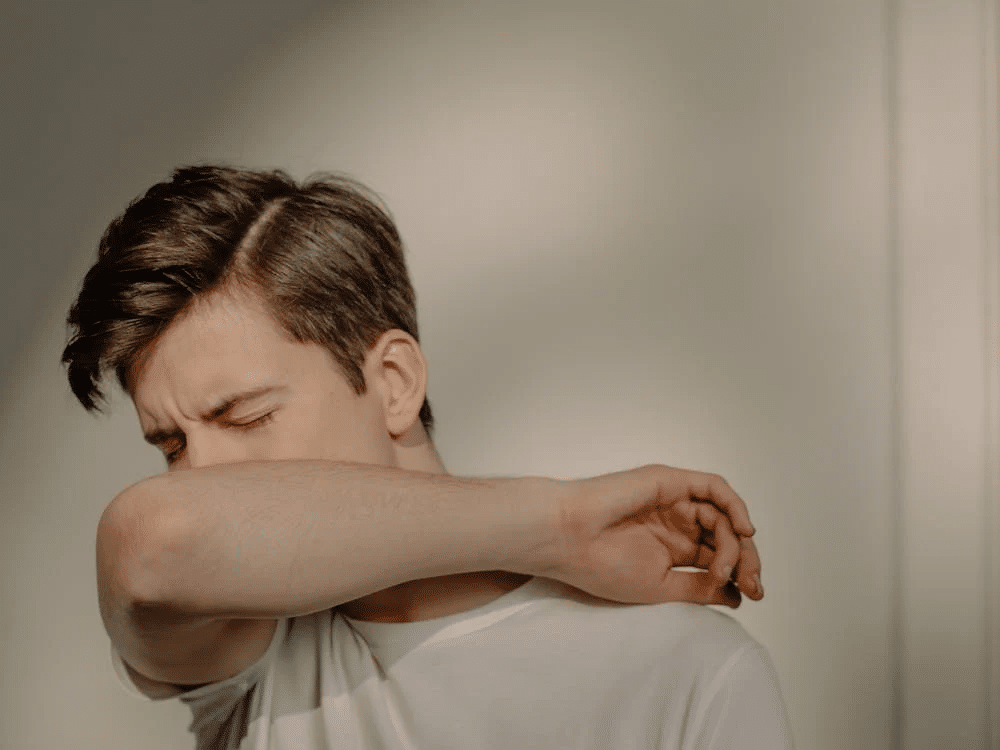 A Sick Man Covering His Mouth
