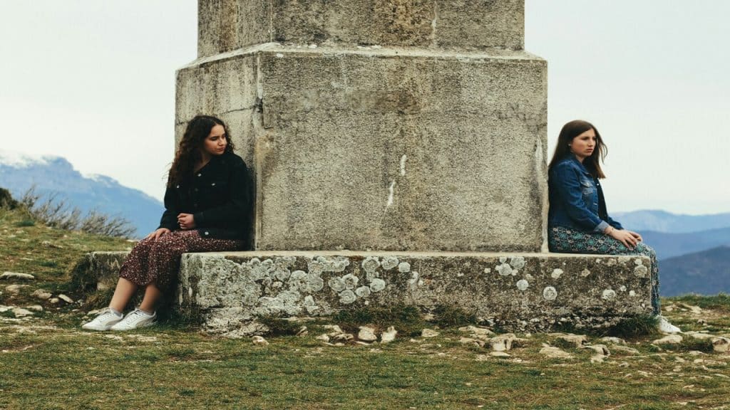 A woman looking sadly at another woman