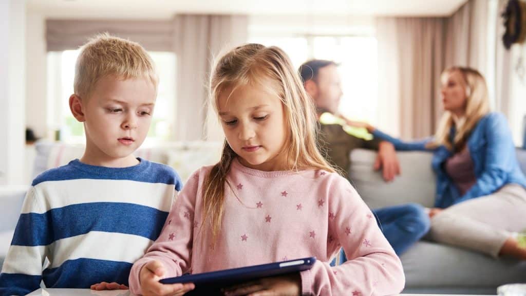 Kids using tablets, and parents are in the background.