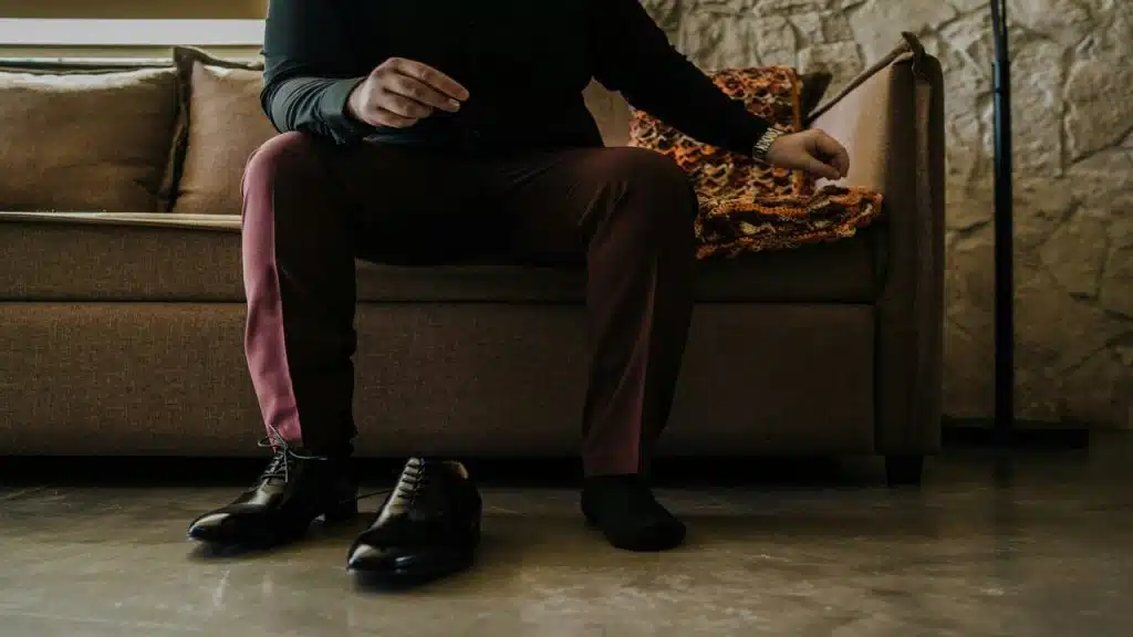 A man putting on his leather shoes