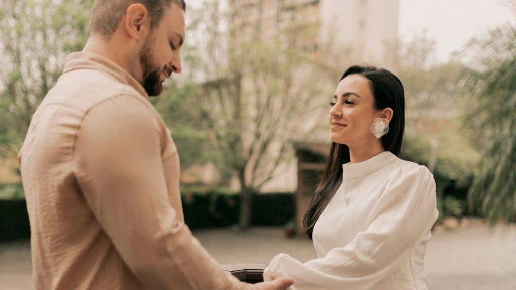 A man and a woman holding hands on a bridge.