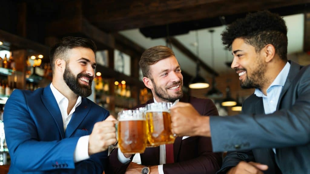 Cheerful old friends having fun and drinking beer at a bar.